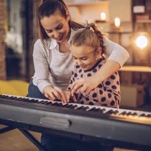 parent playing piano with child